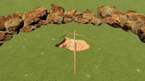 An editor view of a grassy field ringed on the far side by a curve of large rusty brown boulders. In the middle of the grass is a ragged opening about three metres across where orange cave rock shows through below, with a tall wooden ladder pole standing up out of it.