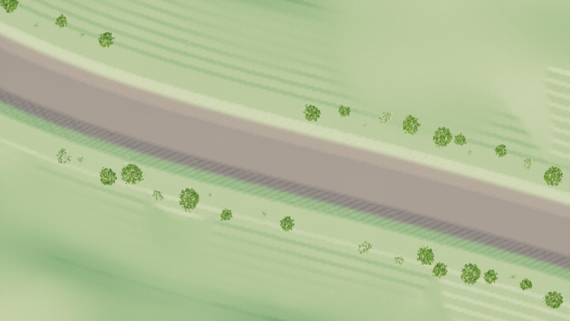A view straight down on pale green fields, with a wide flat grey-brown trench running diagonally across the frame between two lines of small round trees. There is no water in the trench.